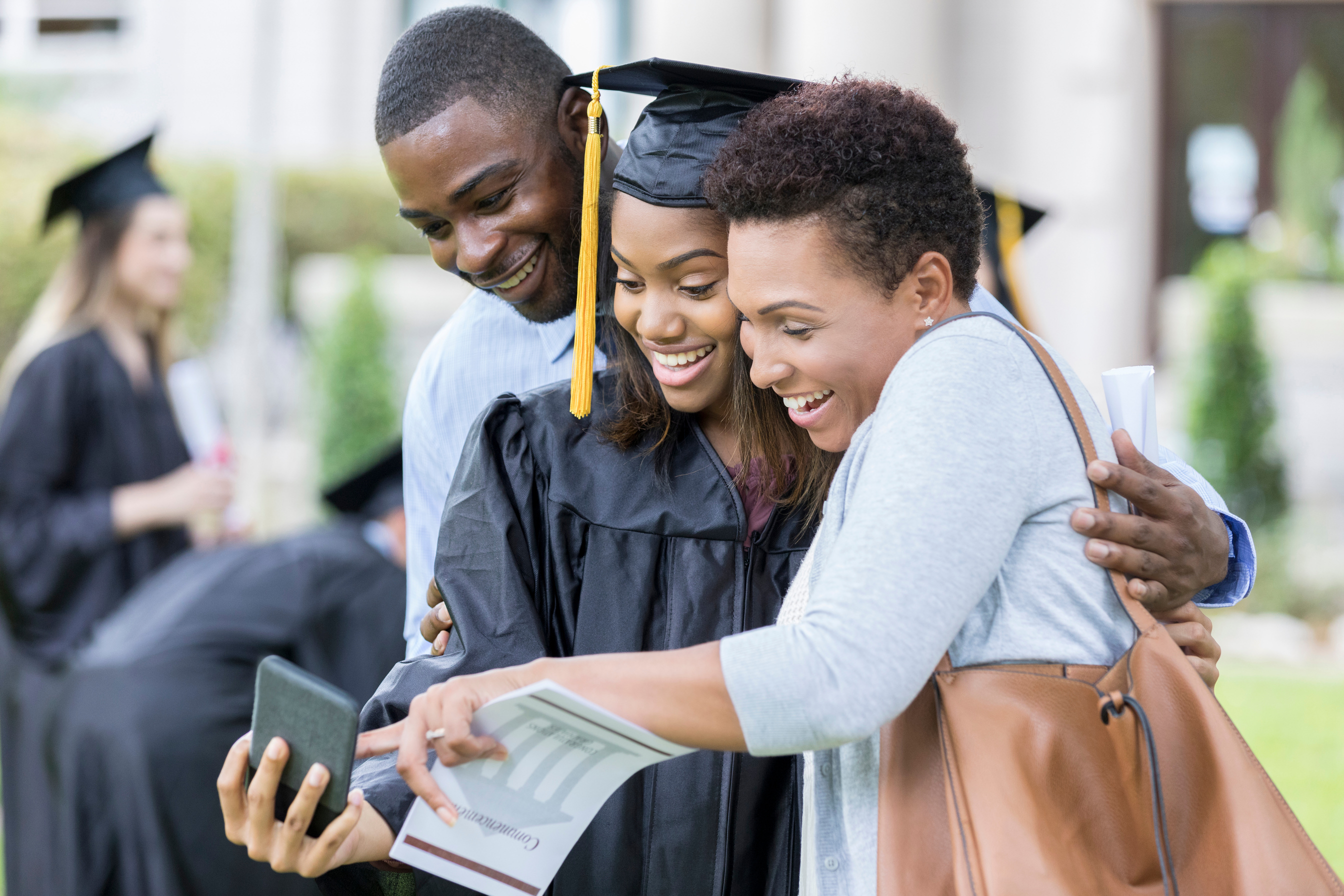 College graduate taking selfie with parents