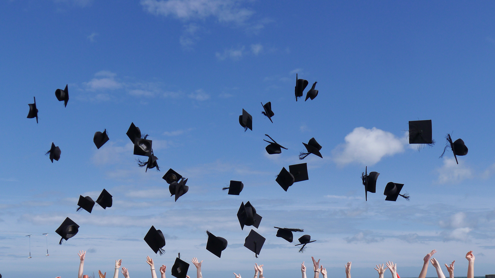 Graduates celebrating and throwing caps